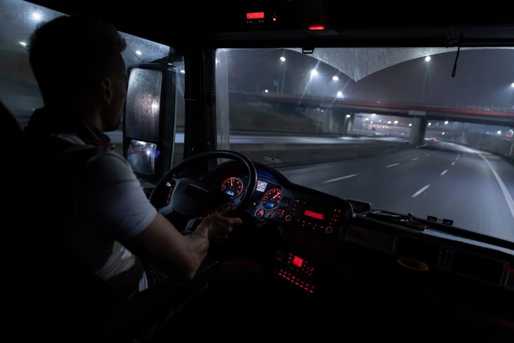 truck drover at the wheel of a truck at night